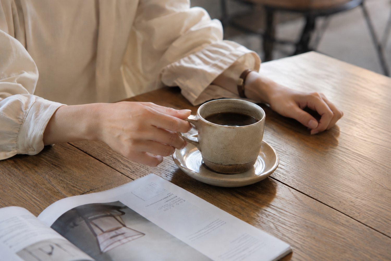 カフェでコーヒーを前にひと息つく手元
